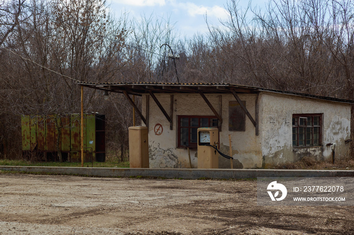 An old abandoned analog fuel station. Industrial zone or production area conquered by nature.