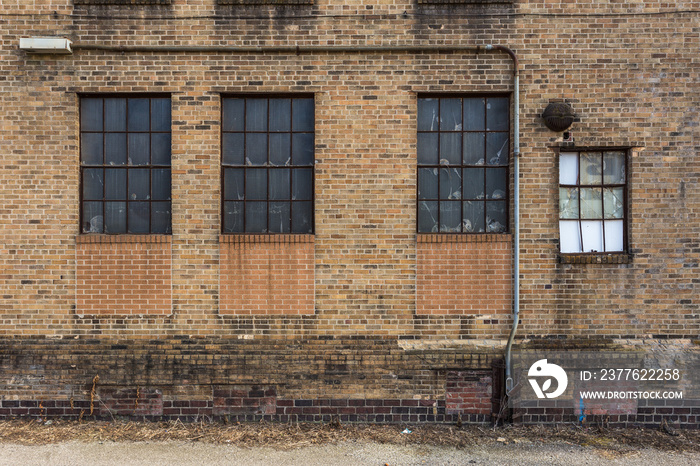 Grid windows on side of vintage brick warehouse in small midwestern town