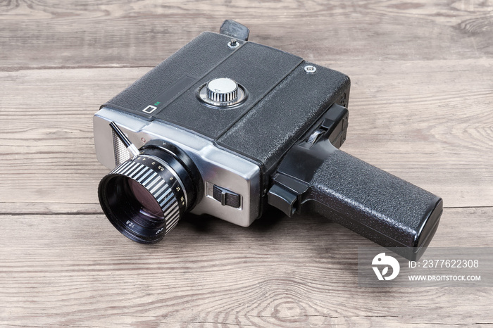 Vintage amateur electric movie camera on an old wooden surface