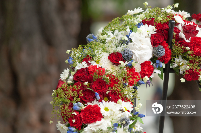 Closeup of a red and white sympathy wreath..