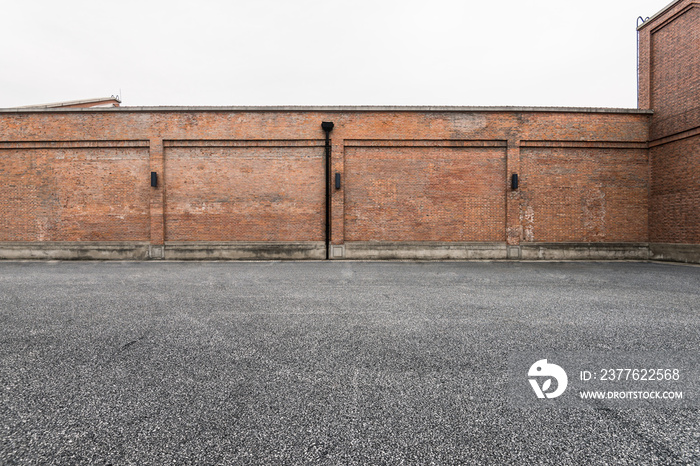 Brick wall and asphalt parking space