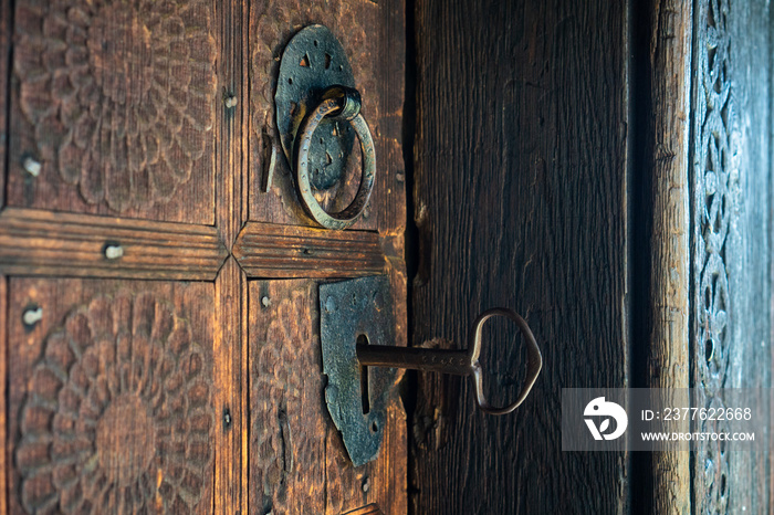 Big key in rustic door of wooden church