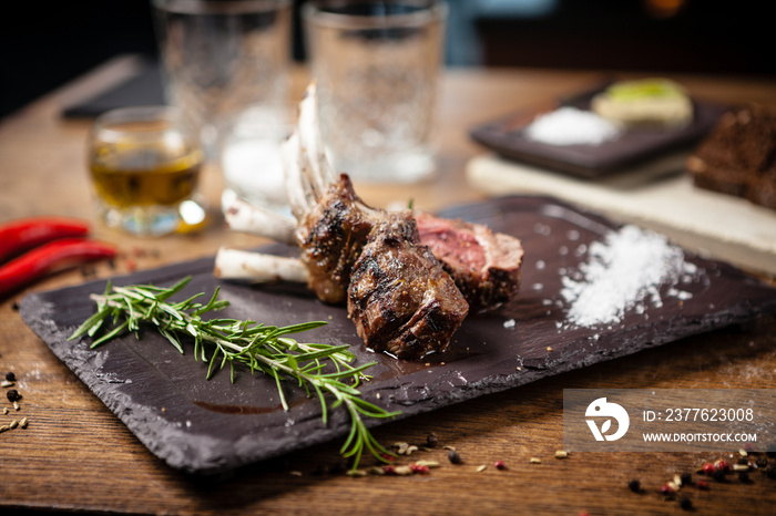 Grilled lamb chops served with a branch of rosemary