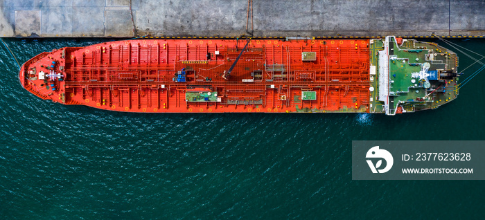 Red tanker ship loading and unloading oil and gas storage at industrial dock port, Business import export petrol and chemical by tanker ship transportation, Loading arm oil and gas offshore platforms.