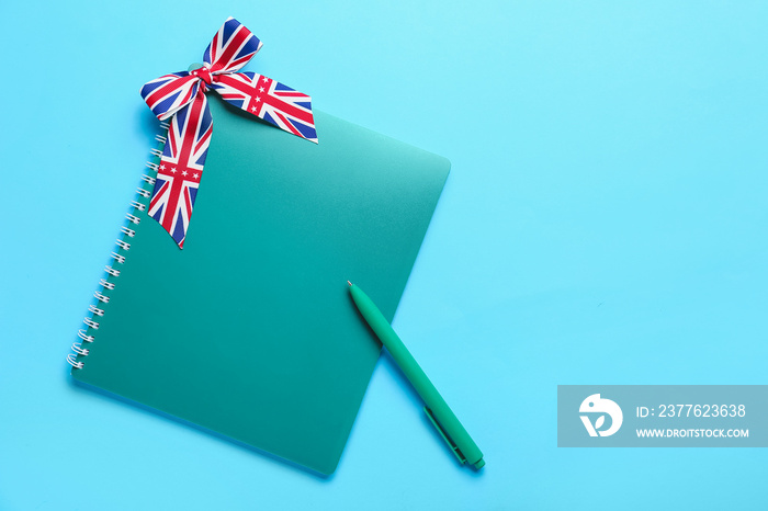 Stationery and ribbon in colors of UK flag on blue background. Concept of learning English