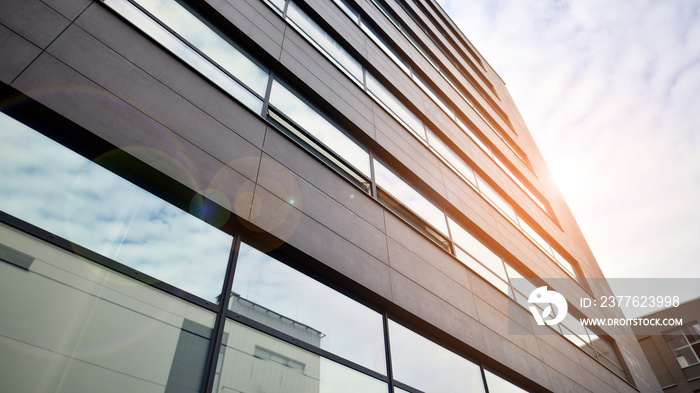 Glass and aluminum facade of a modern office building. View of futuristic architecture. Office building with cloud reflection on windows