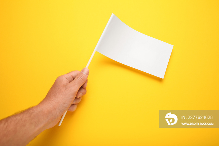 Little white flag mockup in hand for advertising and design. Empty banner, marketing information.