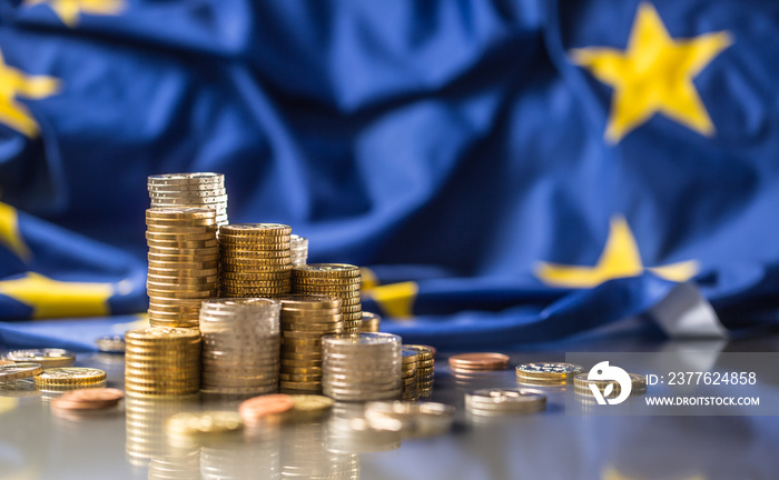 Towers with euro coins and flag of European Union in the background