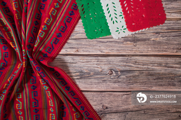 Mexican handmade tablecloth on wooden table with tricolor decorations