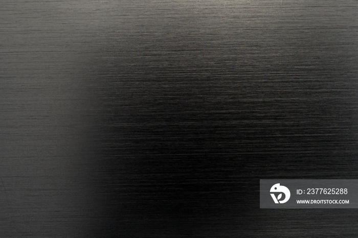 Texture of black anodized brushed aluminum with light reflection