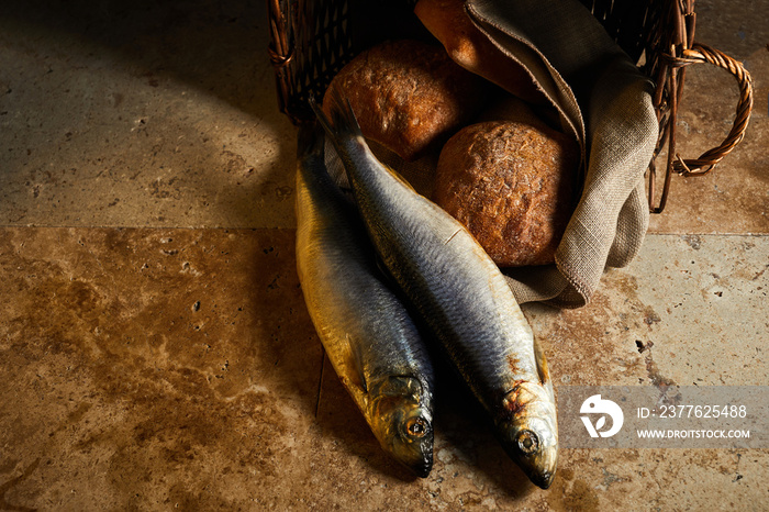 Christianity background. Loaves of bread and two fish in a basket.