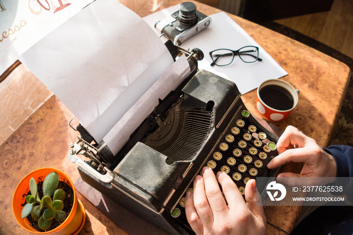 Male writer writing his book on an old antique typewriter. An old antique typewriter.