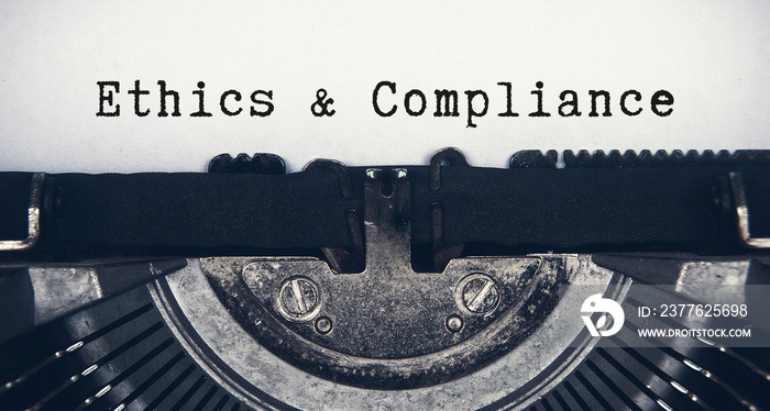 Ethics and compliance text typed on an old vintage typewriter. Compliance concept.