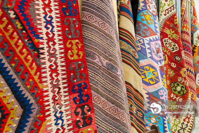 Different traditional turkish carpets hanging on a wall on a street in old town Kaleichi, Antalya, Turkey