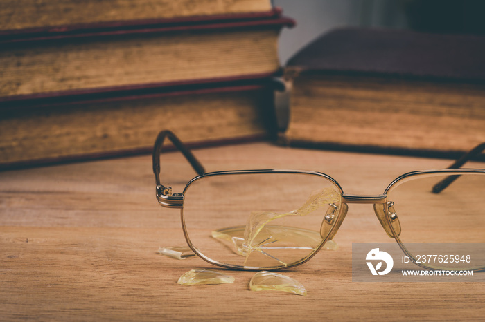 old generation  of information ignored concept, close-up of broken old glasses on wooden table, vintage tone