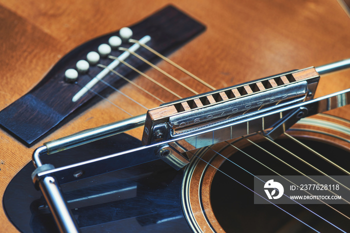 Blues harmonica resting on guitar