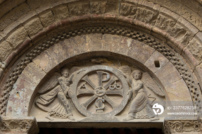 Detail of the figures of angels in relief and the checkered jaques, in the ornate portico of the monastery of San Pedro el Viejo, Huesca, Spain