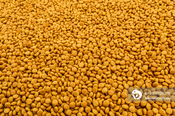 full frame background of small dry orange cat food crockets