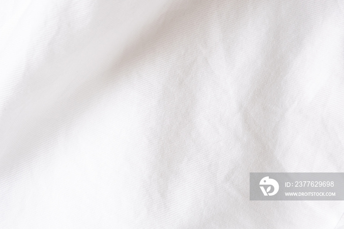 Close up shot at white shirt fabric that show the details of cotton and wool of the cloth. with shade of light and shadow, with copy space for text. Ideal for background or wallpaper.