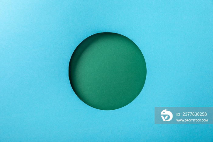 blue paper background with green round hole