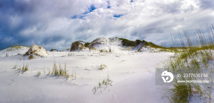 Panorama of a large sand dune standing like a mountain against a stormy sky