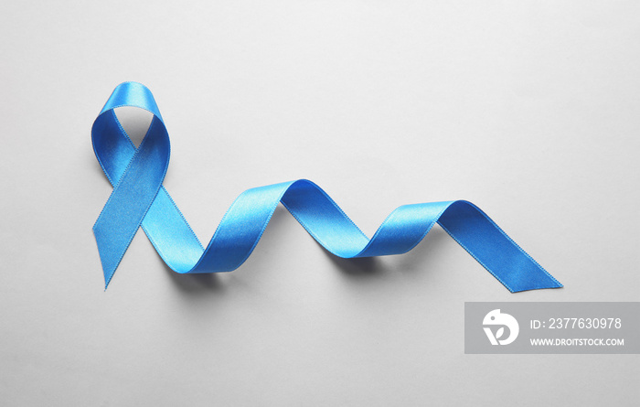 Blue ribbon on light background. Cancer concept