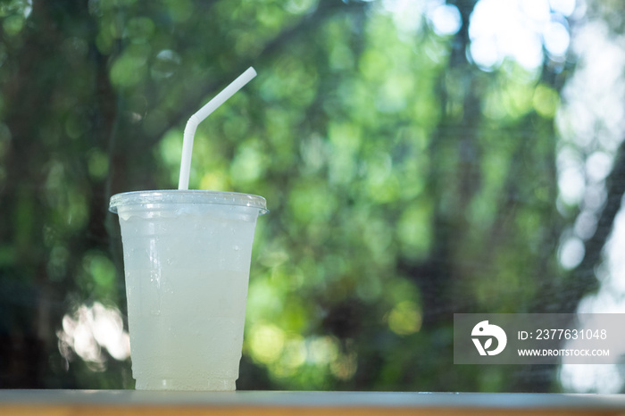 Lemon soda with ice in plastic glass.