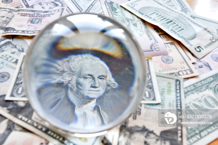 US dollar bill seen through a crystal ball. Creative concept, business, banking, taxes and finance.