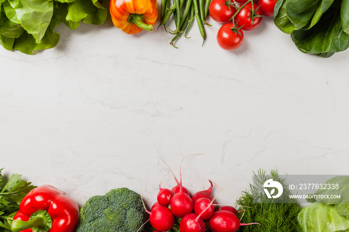 Stone background with a border of fresh vegetables.