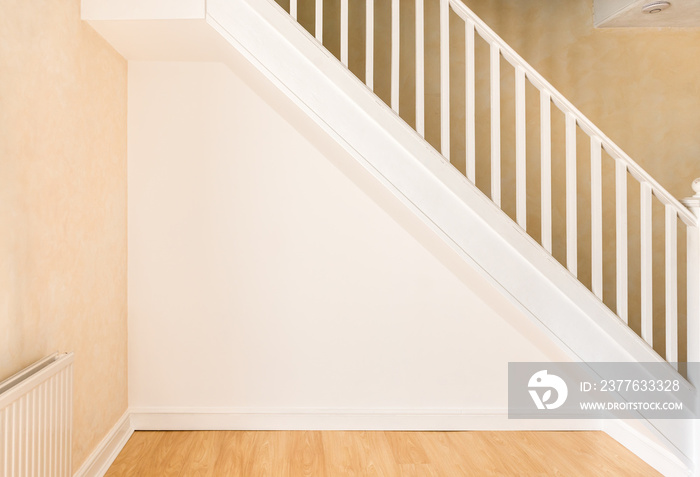 Newly decorated wall under staircase in a domestic room.