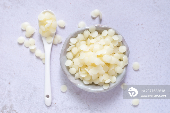 white natural beeswax pellets in white ceranic bowl for homemade natural beauty and D.I.Y. project.