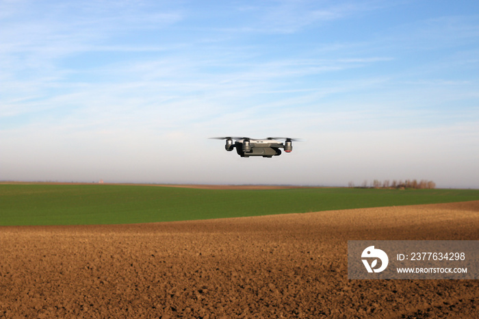 The drone is flying over the plowed field agriculture