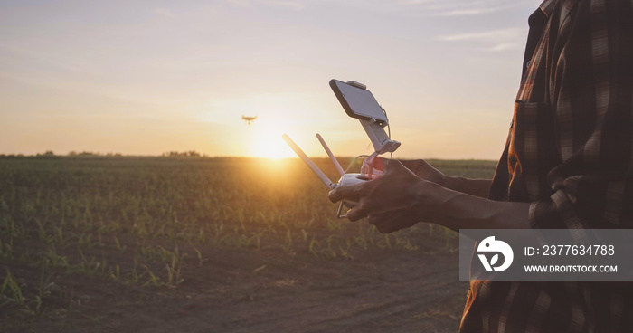 IoT(Internet of Things) smart agriculture industry 4.0 concept.Farmer with drone remote controller in farm. Drone for agriculture and analysis Aerial view of field.