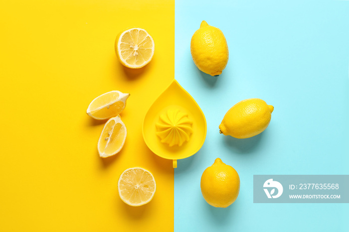 Ripe lemons and juicer on color background