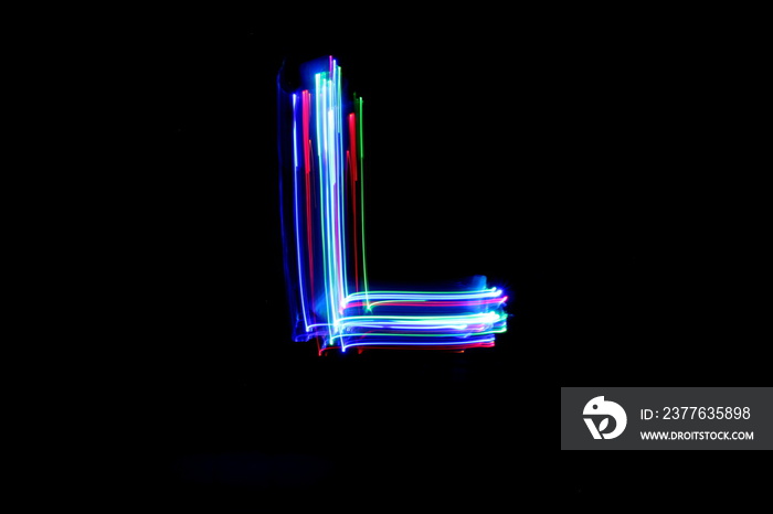 Long exposure photograph of a letter l in neon colour in an abstract swirl, parallel lines pattern against a black background. Light painting photography.