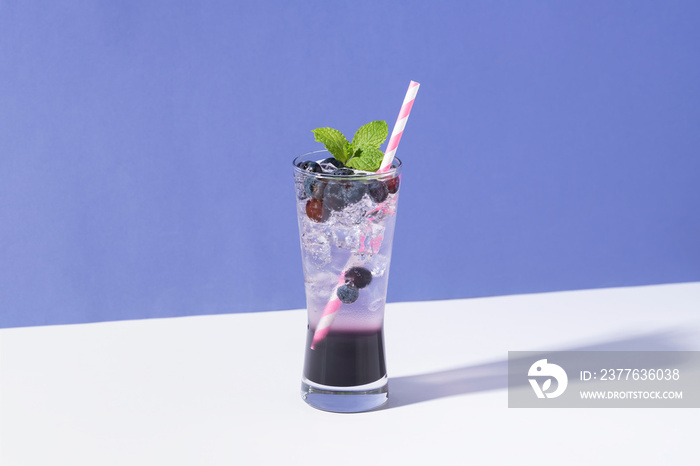 Cold and refreshing  blueberry punch cocktail with mint on purple background. summer drink