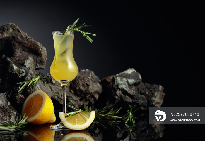 Traditional homemade lemon liqueur limoncello on the black background.