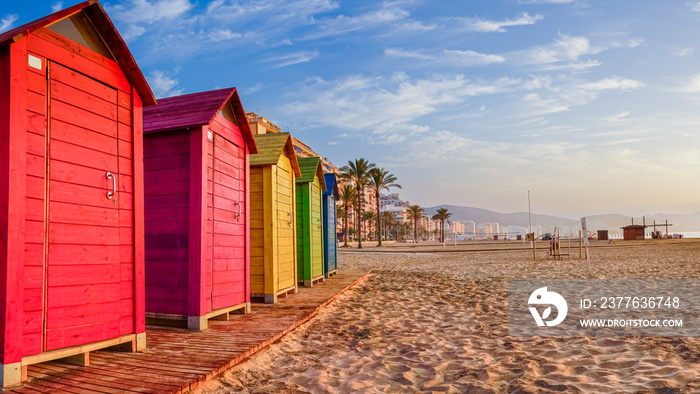 Colorfully painted wooden huts located on the beach by the sea