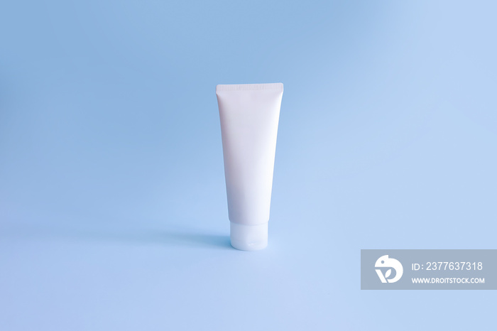 Mock-up of white squeeze bottle plastic tube for branding of medicine or cosmetics. Cosmetic bottle container on blue background. Natural organic spa cosmetics concept. Minimalism.