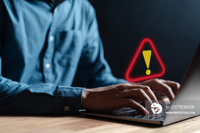 Businessman or it staff , programmer, developer using computer laptop with triangle caution warning sign for notification error and maintenance