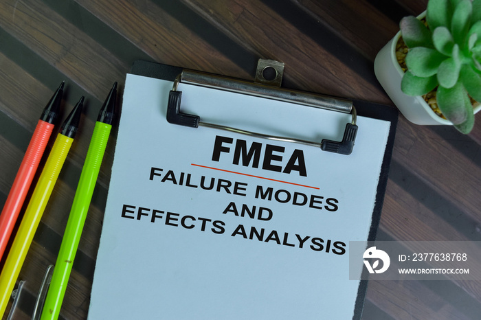 FMEA - Failure Modes and Effects Analysis write on a paperwork isolated on Wooden Table.