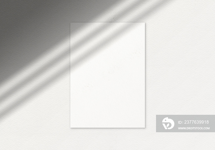 Empty white vertical poster mockup with window shadow on the concrete wall. Flat lay, top view.