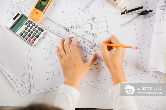 Architectural project workplace. Architect drawing with ruler on house plan blueprint paper for repair tools on table desk at architecture office, architect sketching construction, Engineering tools