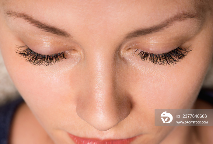 Close-up face of beautiful young woman with beautiful big eyelashes and eyebrows. Macro of human eye - close.