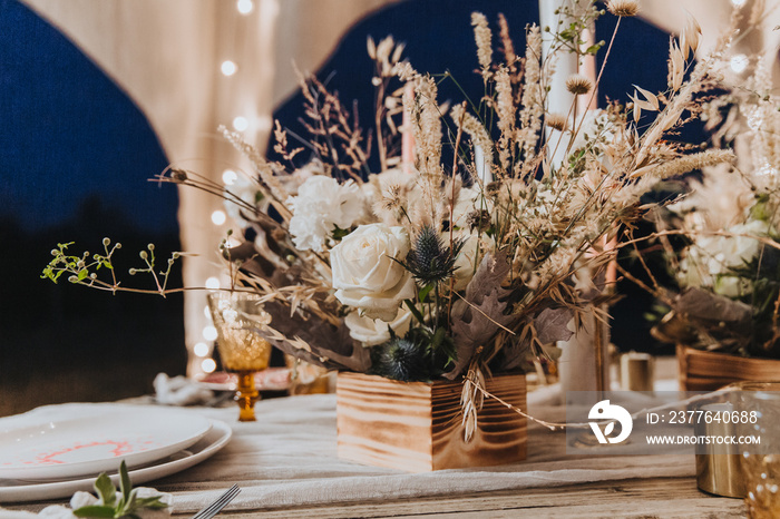 Bouquet of flowers in boho style, decorate the festive table, dried flowers, white roses, floristic concept