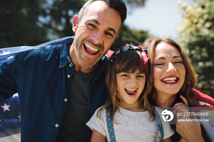 Happy family standing together holding the american flag