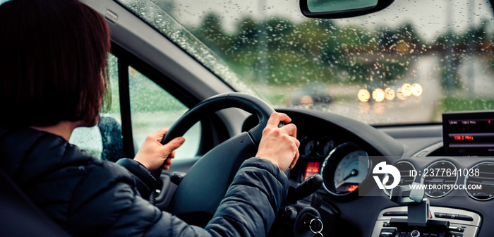 Woman driving car on the motorway in the rain