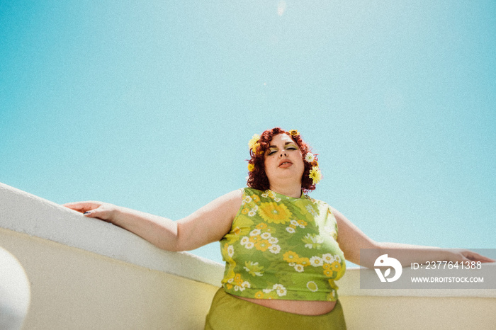 plus size woman with red hair against blue sky