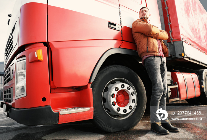 Handsome driver near big modern truck outdoors