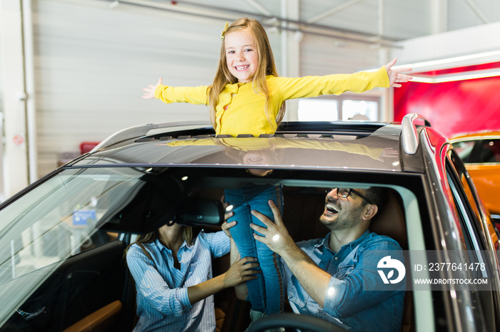 Happy family buying a new car at the car showroom.